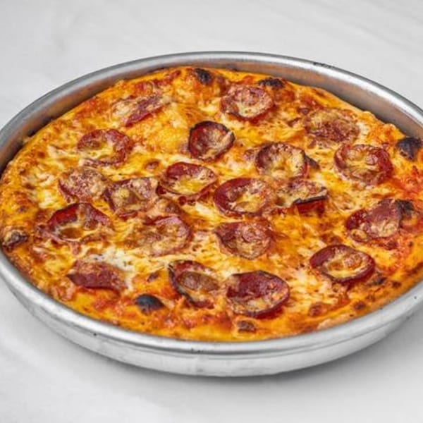 A freshly baked pepperoni pizza, golden brown with melted cheese, in a metal pan.